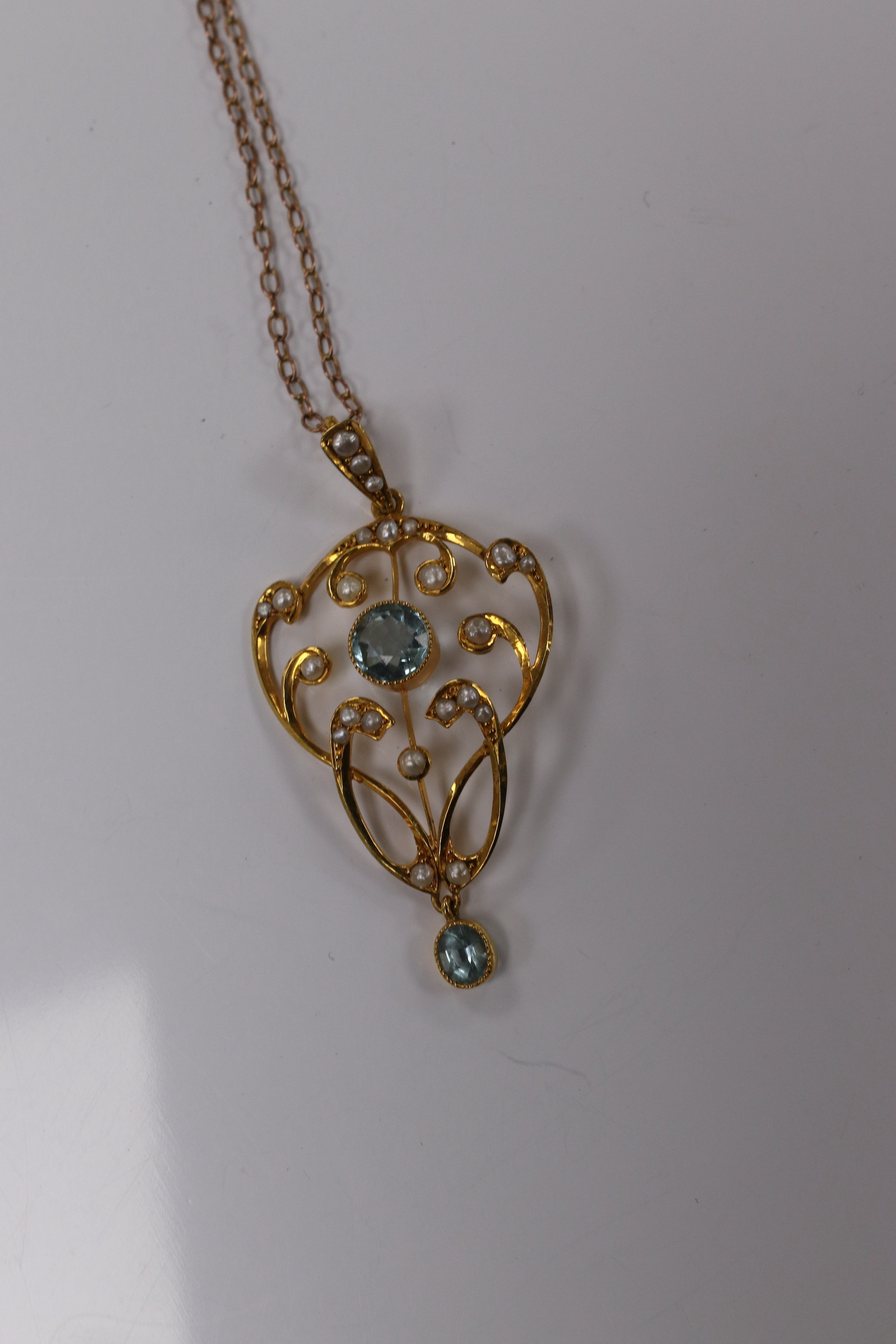 An Edwardian 9ct and gem set drop pendant, 45mm, on a yellow metal fine link chain, 36cm, gross weight 4.2 grams. Condition - good